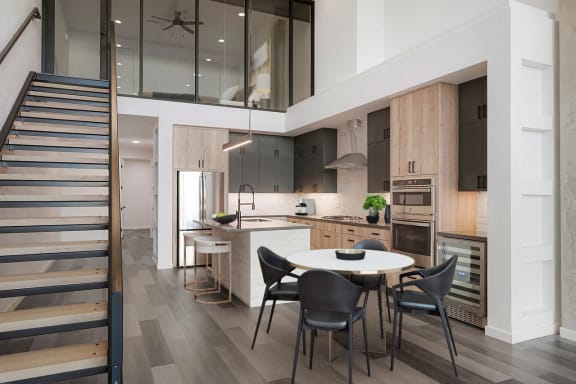 a large kitchen with wooden floors and wooden cabinets and stainless steel appliances