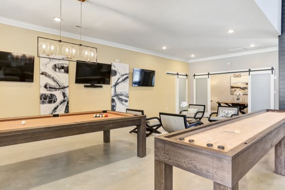 a billiards room with two pool tables and a tv