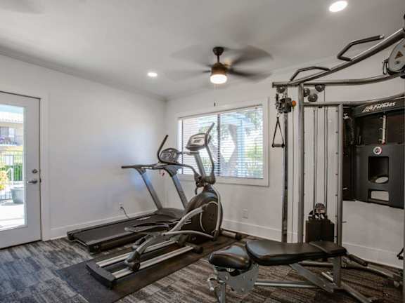 A spacious home gym with a treadmill, elliptical trainer, and other exercise equipment.