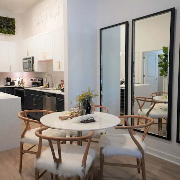 A modern kitchen with a white table and chairs.