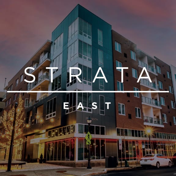 a new apartment building on a city street at sunset