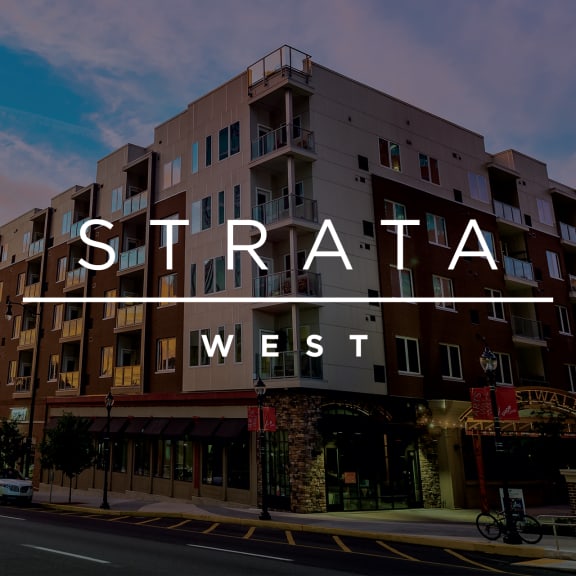 a new apartment building on a city street at sunset