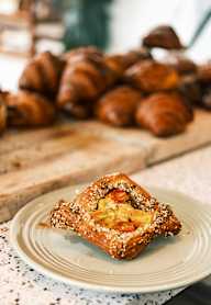 A pastry with sesame seeds on top is on a plate.