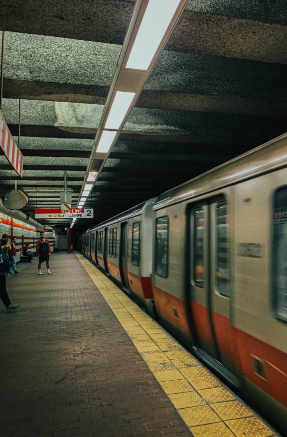 a subway train at a subway station with people on the platform