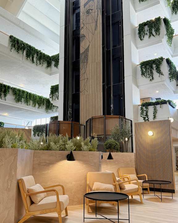 A modern living room with wooden furniture and a large plant.