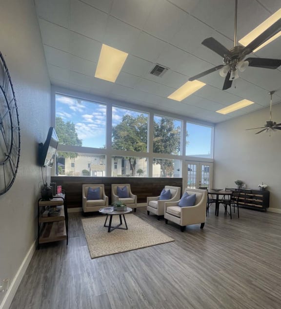a living room with couches and chairs and a large window at Whispering Oaks in  Conroe, TX