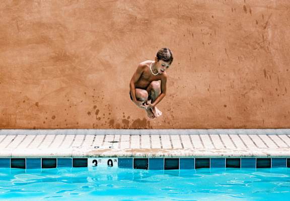 A boy diving into a pool from a diving board.at 810 Ashland, Santa Monica, CA