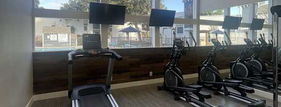the gym has a lot of exercise equipment and windows at Whispering Oaks in  Conroe, TX