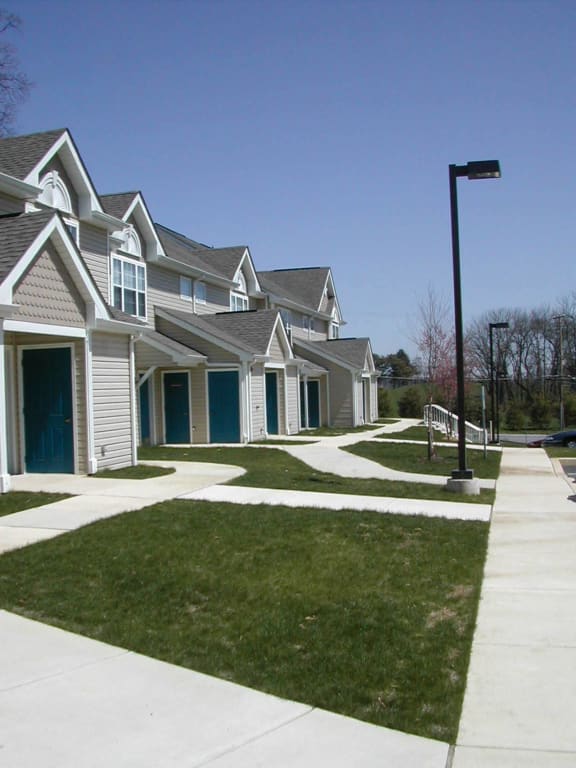 a row of houses with blue doors and white siding