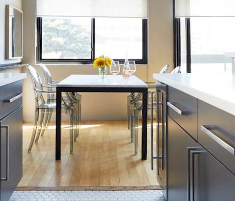 A modern kitchen with a table and chairs by the window.