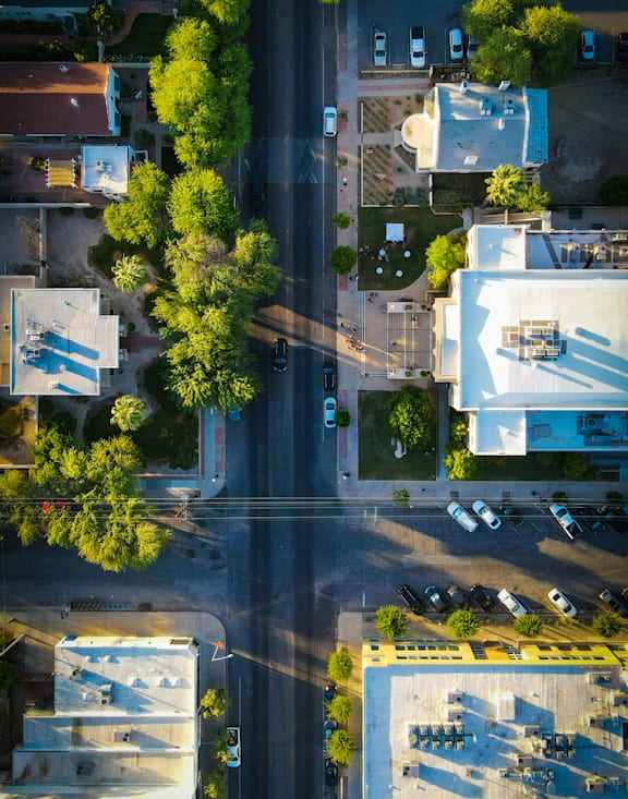 A street view of a residential area with houses and parked cars.