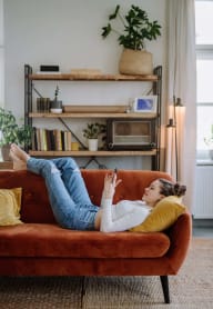 a woman laying on a couch looking at a phone at Cypress River, South Carolina, 29456