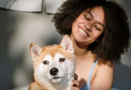 a woman sitting on a bed with a dog