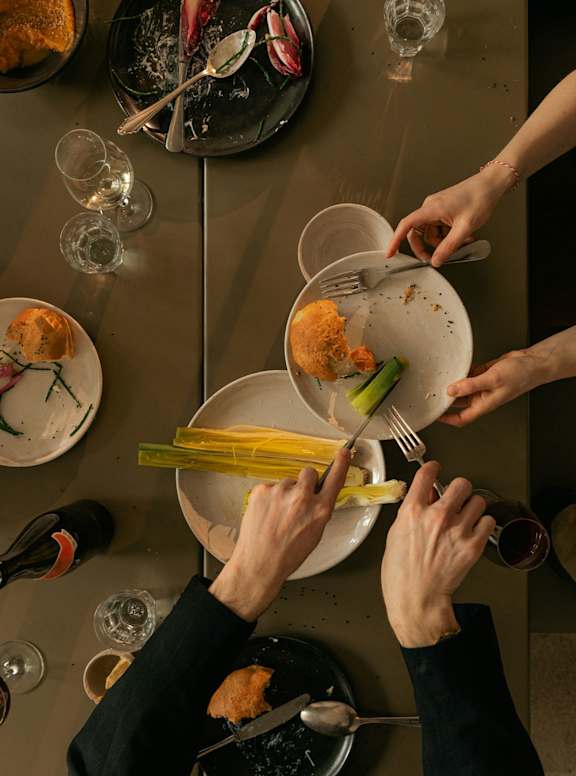 A group of people are sitting around a table eating food.