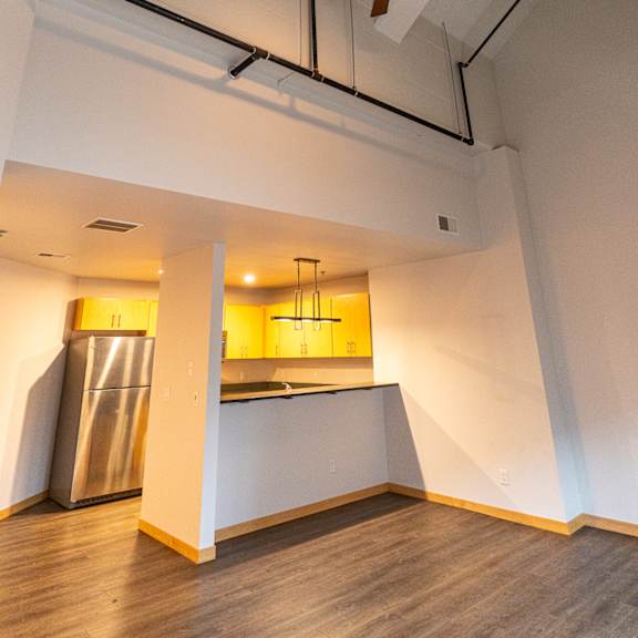 A kitchen with a refrigerator and a ceiling fan.