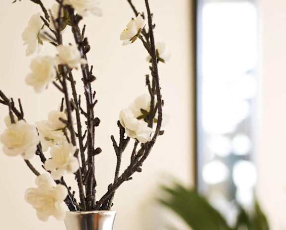 A vase with white flowers sits on a table.