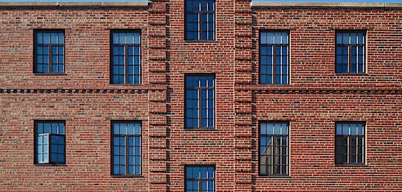 the front of a red brick building with a brown door