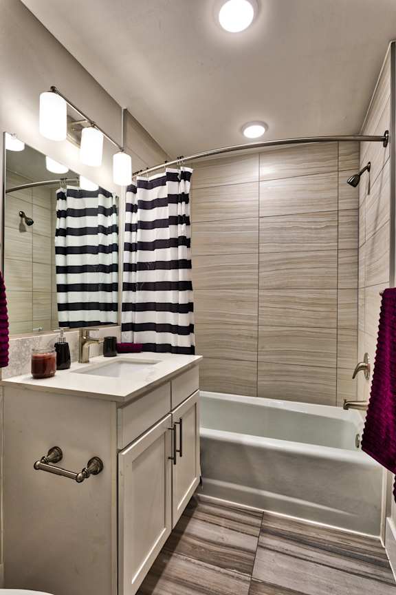 A bathroom with a white sink and a white bathtub.
