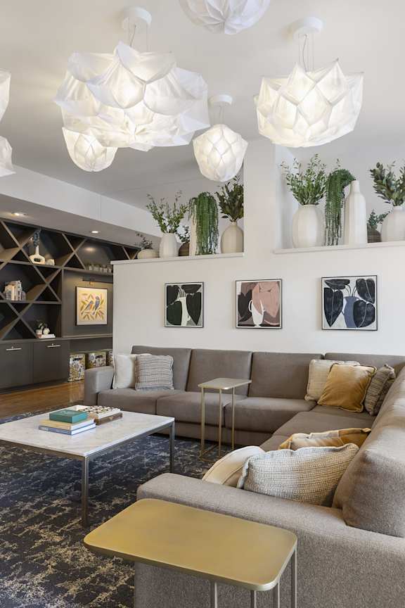 A living room with a grey couch, a white coffee table, and a rug with a black and gold pattern.