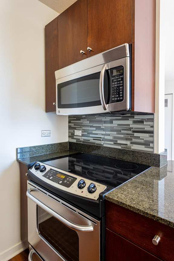 A modern kitchen with a stove top oven and microwave above it.