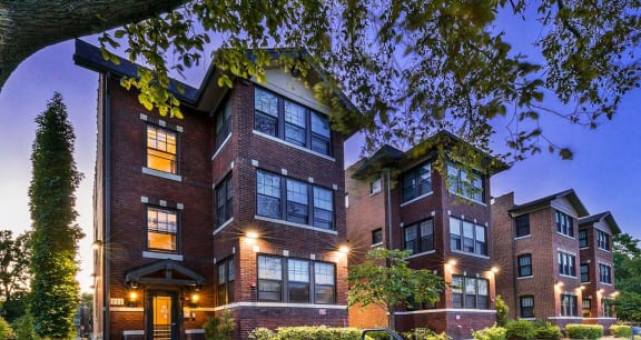the exterior of a brick apartment building at night
