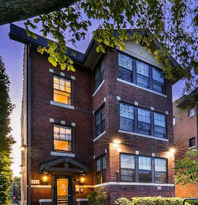the exterior of a condo building at night with lights on