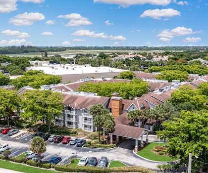 an aerial view of a neighborhood with cars parked in a parking lot