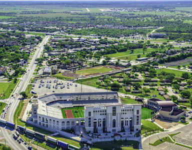 A large white building with a green field in front of it.