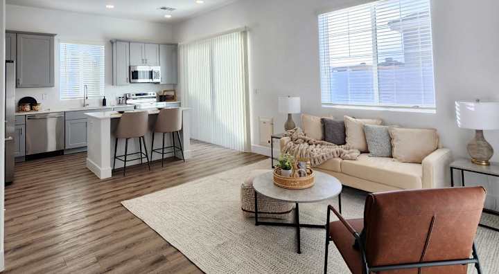Furnished apartment living area shown — representative home at Zora Encanto.