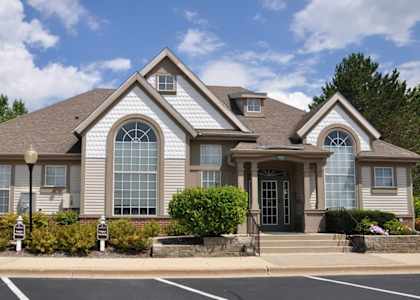 the front of a house with a driveway and a parking lot