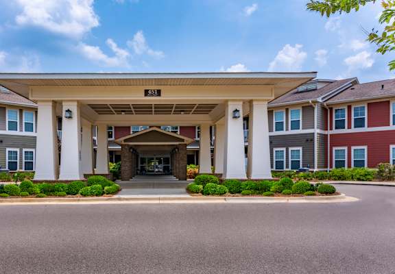 A building with a covered walkway entrance and a sign above it.