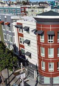 A red building with a white dome on top is in the middle of a street.