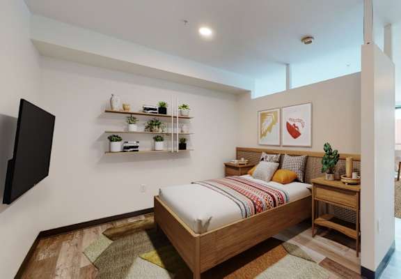A bedroom with a bed, a TV, and a window.