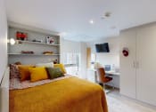 Thumbnail 5 of 8 - a bedroom with a bed and a desk