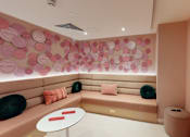 Thumbnail 7 of 8 - A room with a pink wall and a TV on the wall.