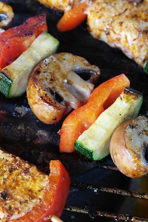 a grill with skewers of meat and vegetables