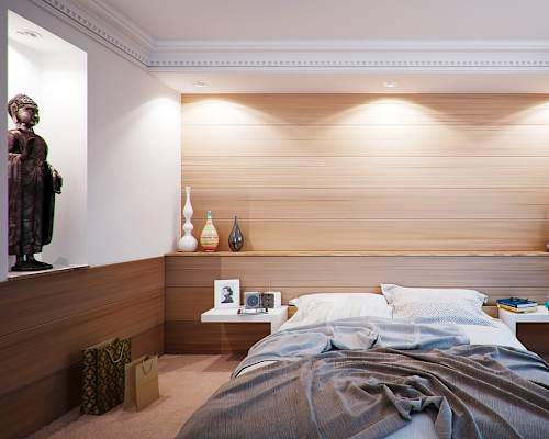 A bedroom with a bed, nightstands, and a statue.