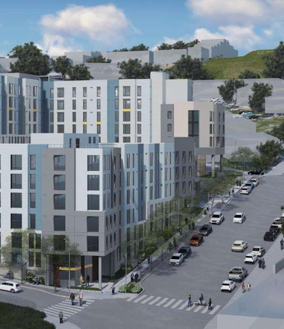 A modern multi-story building with a parking lot in front.