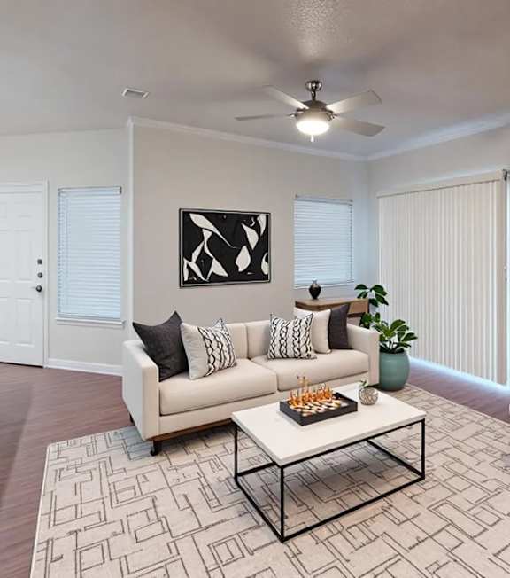 A living room with a white couch, a coffee table, and a rug.