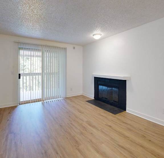 A living room with a fireplace and a couch at Ellyson Apartment Homes in Tacoma, WA