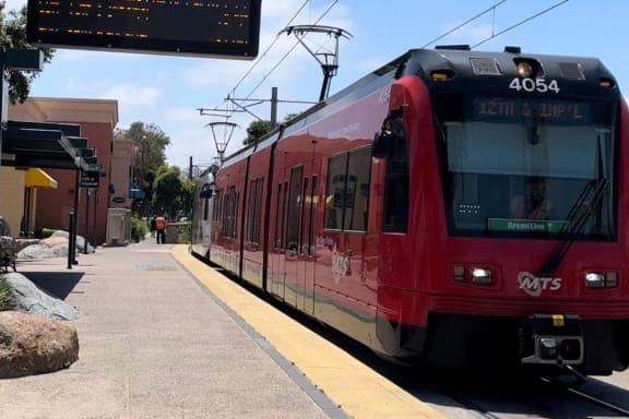 a red train is stopped at a train station