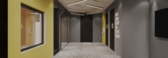 a long corridor with grey walls and a yellow wall