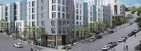 A street view of a residential area with cars and pedestrians.