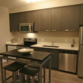 a kitchen and living room with a table and a tv