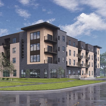 A modern apartment building with a wet street in front.