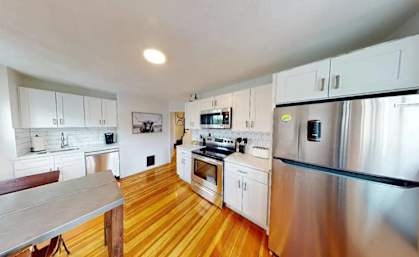 A kitchen with wooden floors and stainless steel appliances.
