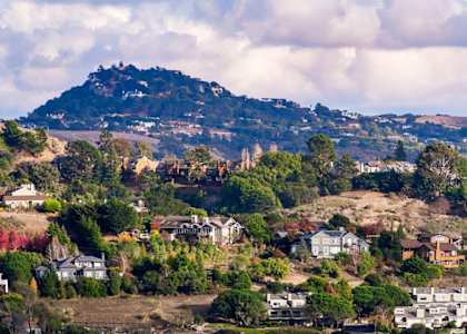 A mountain is in the background of a residential area.