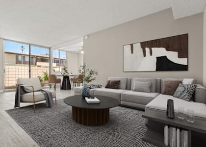 a living room with a couch and a table in front of a window