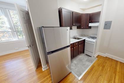 A kitchen with a refrigerator, oven, and sink.
