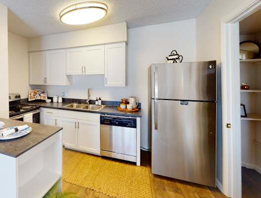 a kitchen with stainless steel appliances and white cabinets